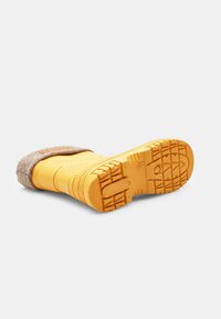 Botas de invierno de goma amarilla con parte superior de fieltro marrón, suela texturizada y patrón de banda gruesa para un buen agarre. Presenta un diseño de punta redonda.