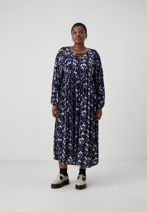 Robe longue et fluide avec un motif en zigzag bleu et blanc, encolure ronde et détail en forme de trou de serrure. Tissu doux avec des manches longues.