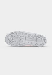 Η σόλα ενός λευκού παπουτσιού Adidas που δείχνει υφασμένα μοτίβα πέλματος και το λογότυπο Adidas στο κέντρο της σόλας.