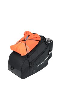Zaino nero con una finitura texturizzata, dotato di dettagli riflettenti e una giacca arancione compatta fissata sopra con cinghie elastiche.