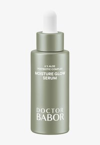Bottiglia di siero in vetro verde con tappo contagocce bianco. L'etichetta riporta "Complesso Postbiotico di Aloe al 6%" e "Siero Idratante Luminoso" in testo bianco.