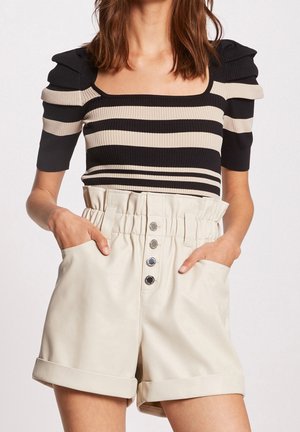 Haut côtelé à rayures noires et beiges avec des manches courtes et un décolleté carrée, associé à un short en simili cuir crème avec une taille froncée et une fermeture à bouton.