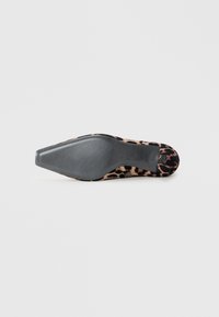 Chaussure à talon haut en imprimé léopard avec un nez pointu, en matériau en suède, semelle en caoutchouc noir et design texturé en dessous.