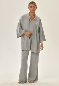 Szary zestaw odzieży domowej z szerokimi spodniami i topem w stylu kimono o luźnym kroju oraz teksturowanej tkaninie.