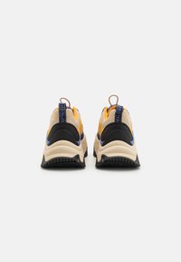 Masywne, sportowe sneakersy z cholewką z siateczki i materiału syntetycznego, z żółtymi, czarnymi i niebieskimi akcentami oraz grubą szaro-skalną podeszwą.