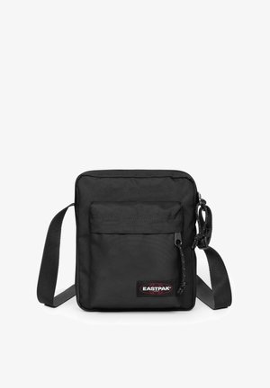 Černá messenger taška z odolné látky, vybavená předním zipovým kapsou, nastavitelným popruhem a detailem s logem Eastpak. Kompaktní obdélníkový tvar.