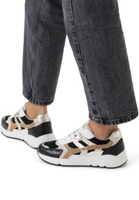 Black, silver, and beige sneakers with a chunky sole; features textured fabric and metallic accents; designed with distinct geometric shapes.