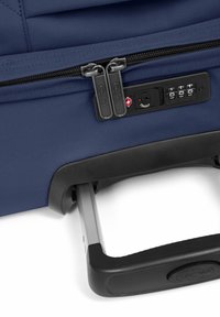 Navy travel suitcase s dvojitým zipem, kombinovaným zámkem a teleskopickou rukojetí s texturovaným černým úchytem. Elegantní a odolný design.