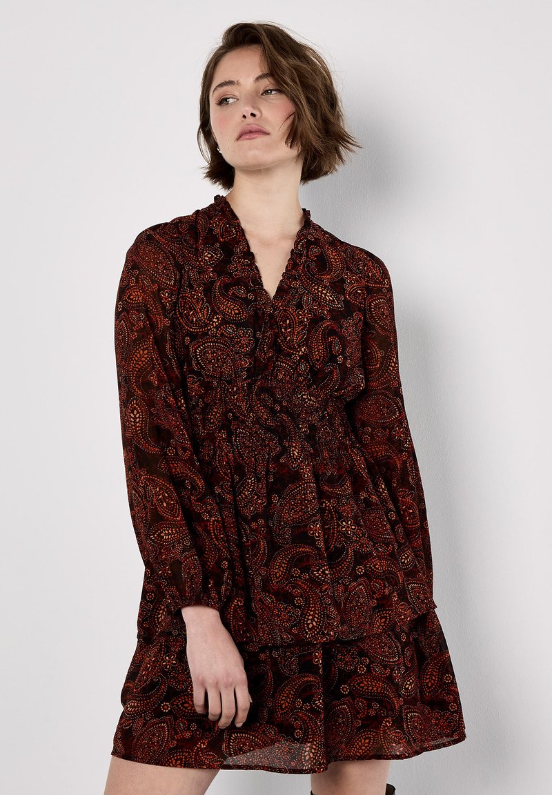 Abito a maniche lunghe in tessuto rosso scuro, con motivo paisley, scollatura a V e vita arricciata con gonna a strati.