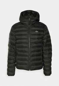 Schwarze Pufferjacke mit Reißverschluss und verstellbarem Kapuzen. Sie verfügt über horizontale Nähte und ein kleines grünes Logo auf der Brust.
