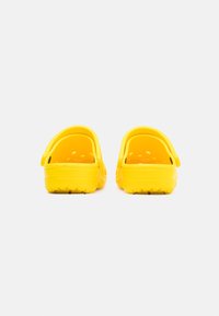 Yellow clogs with a smooth, glossy texture. Open back and front ventilation holes. Soft material and rugged sole for grip.
