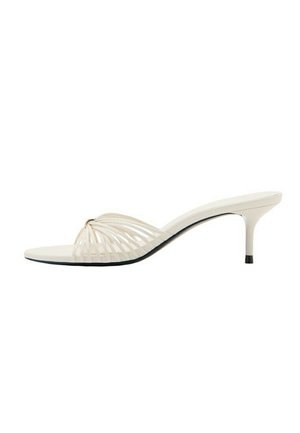 Mule beige à bout ouvert avec talon stiletto et fines lanières courbées à l'avant.