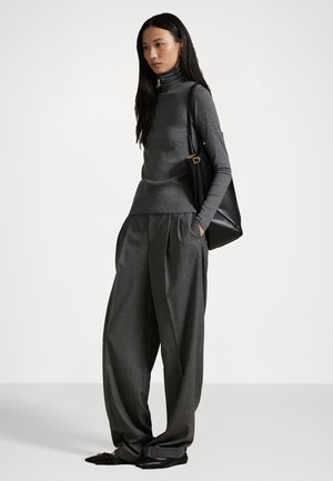 Pulover gri cu guler înalt, pantaloni gri cu pliuri, largi, și geantă tote neagră. Textură netedă și top ajustat contrastând cu pantaloni cu picior larg.