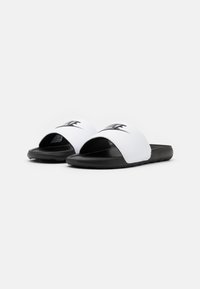 Fehér, nyitott orrú csúszó szandálok fekete gumitalppal és a felső pánton kiemelkedő fekete Nike logóval. Simára csiszolt felület.