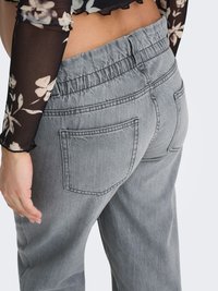 Pelēkas džinsa bikses ar brīvu piegriezumu, elastīgu jostasvietu un divām aizmugurējām kabatām ar smalku šuvju dizainu. Teksturēts audums.