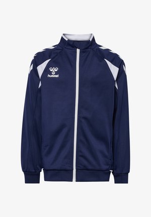 Marineblauw sportjack met witte rits, witte schouderaccenten, geribbelde manchet en hummel-logo op de linkerborst.