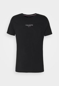 Camiseta de algodón negra con cuello redondo y mangas cortas. Presenta texto bordado en blanco "TOMMY HILFIGER EST. 1985" con un pequeño acento de bandera.