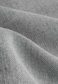 Szürke szövött anyag texturált felülettel, finom szövött mintával, amely lágy tapintású és könnyű.