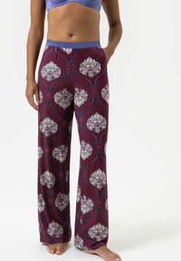 Burgundy en witte pyjamabroek met bloemenpatroon, voorzien van blauwe accenten. Heeft een brede tailleband en een losse, comfortabele pasvorm.