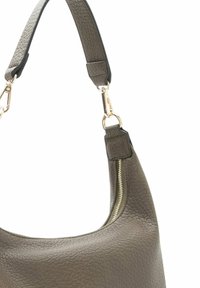 Braune Lederhandtasche mit strukturiertem Oberflächen, ausgestattet mit einem schwarzen Tragegurt und goldenen Beschlägen. Eine Reißverschlusstasche ist seitlich angebracht.