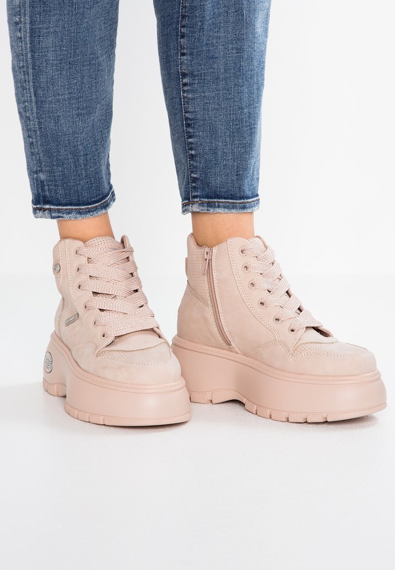 Ljust rosa hög-top sneakers i texturerad mocka, tjock plattformssula, snörning fram och en sidoglada för enkel åtkomst.