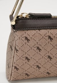 Brown patterned handbag with a textured fabric featuring small cat motifs, accented with a dark brown leather trim and gold hardware.
