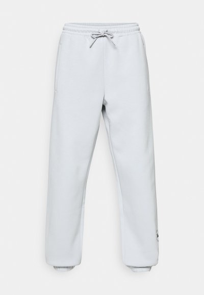 Light gray sweatpants in a soft material. Features an elastic waistband with drawstring, side pockets, and ribbed cuffs at the ankles.