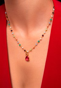 Collana di gemme colorate con catena d'oro, dotata di un grande ciondolo a goccia rossa e vari piccoli perline di diversi colori.