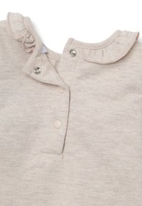 Lichtbeige katoenen rompertje met een gerimpelde kraag, drukknoopsluitingen en een zachte textuur. Bevat twee ronde drukknoopjes en een decoratieve stiknaad.