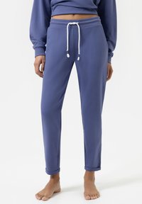 Paarse katoenen sweatpants met een trekkoord in de taille, slim fit en omgeslagen manchetten. Gladde textuur met contrasterende witte trekkoordaccenten.