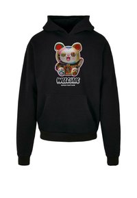 Sudadera negra con un gráfico de un oso de dibujos animados colorido en el frente con el texto "BIENVENIDO" y "BUENA SUERTE", bolsillo tipo canguro y puños acanalados.