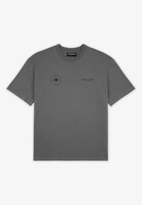Camiseta de cuello redondo de manga corta en gris oscuro con un pequeño logotipo circular negro y el texto "PEGADOR" en el pecho, dispuesta plana sobre un fondo blanco.
