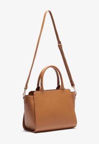 Bolso de cuero marrón claro con dos asas superiores y correa de hombro desmontable. Forma rectangular con textura suave y detalles mínimos en los herrajes.