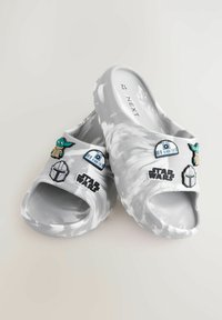 Szare sandały z płaską podeszwą o marmurkowym wykończeniu, z kolorowymi naszywkami przedstawiającymi postacie i logo z serii Star Wars na wierzchu. Teksturowana wkładka.