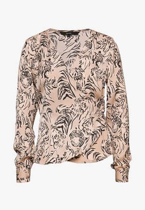 Blouse beige à manches longues avec motif de visage de tigre abstrait noir et rayures, poignets à boutons et col en V.