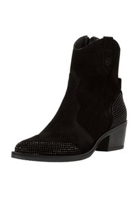 Stivale alla caviglia in suede nero con punta a punta, impreziosito da borchie nere lungo la parte frontale e laterale. Tacco basso impilato, chiusura con zip.