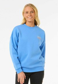 Sudadera azul con cuello redondo y mangas largas, que presenta un logo bordado en el lado izquierdo del pecho. Confeccionada con un tejido suave y de corte relajado.