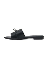 Zwarte leren slidesandaal met een platte zool, brede banden en een ronde hardware-accent op de bovenkant. Textuurafwerking.
