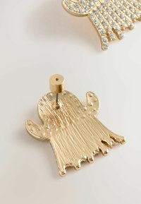 Gold-tone metal ghost-shaped earring with textured surface and stud backing on a light background.