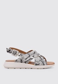 Sandales à talons avec imprimé serpent blanc et noir, design à bandes croisées, semelle intérieure rembourrée et semelle en caoutchouc légère et texturée. Boucle ajustable.