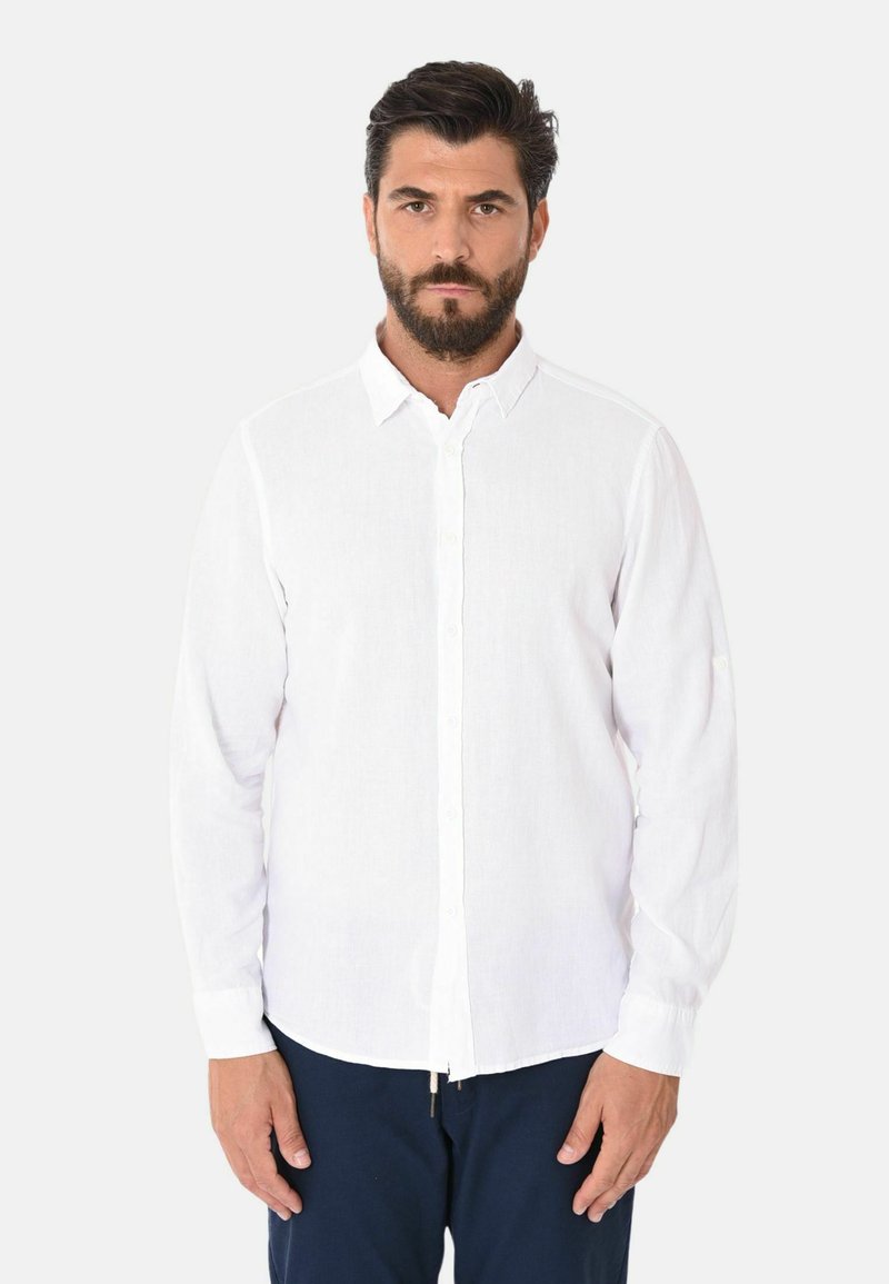 Camicia bianca a maniche lunghe realizzata in un tessuto leggero, con chiusura a bottoni e colletto a punta. Trama liscia con una vestibilità informale.