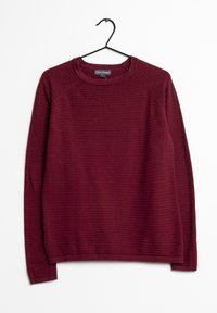 Burgundy neule, jossa on ribattua pintaa, pyöreä pääntie ja pitkät hihat. Ripustettu mustalle koukulle valkoista taustaa vasten.