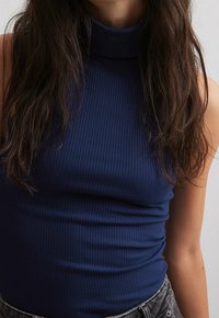 Top de cuello alto de canalé navy, material elástico, diseño ajustado, cuello alto, con una textura suave y un acabado limpio en las sisas.