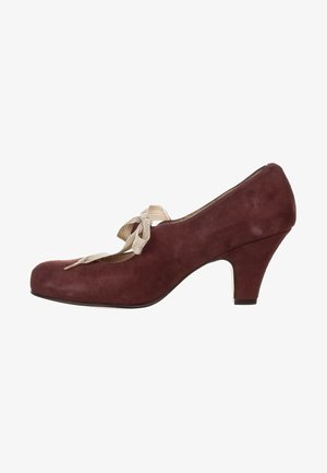 Burgundy suede high heel shoe with a rounded toe, featuring a decorative beige ribbon bow at the front and a curved heel.