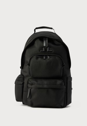 Zaino nero in nylon con più scomparti con cerniera e manico superiore, mostrato su uno sfondo chiaro uniforme.