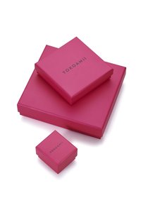 Tres cajas de regalo apiladas de color rosa de diferentes tamaños con "YOKOAMii" impreso en las tapas sobre un fondo blanco.