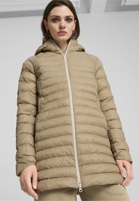Tan pufferjakke med hætte, der har et horisontalt quiltet design, forside-zipper og subtilt logo. Glat, letvægtsstof.