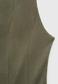 Veselă fără mâneci în verde măsliniu, cu o textură canelată și detalii cu panouri, având margini curate și un design ajustat.