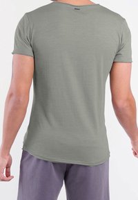 Olijfgroene t-shirt met korte mouwen en een ronde hals. Zachte textuur, licht gebogen zoom en casual pasvorm. Geen zichtbare patronen of accenten.