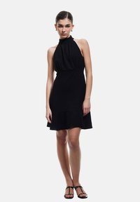 Schwarzes Neckholderkleid mit gerafftem Oberteil und ausgestelltem Saum. Aus leichtem Stoff gefertigt, bietet es eine glatte Textur und ein minimalistisches Design.